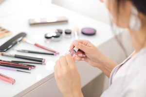 woman putting lipsticks and cosmetics products